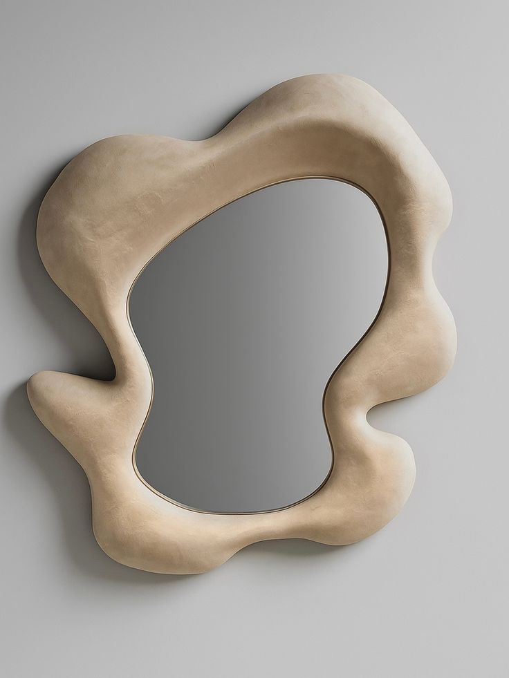 Sculpted plaster organic cloud mirror close-up showing thick sand-white hand-sculpted frame on grey wall