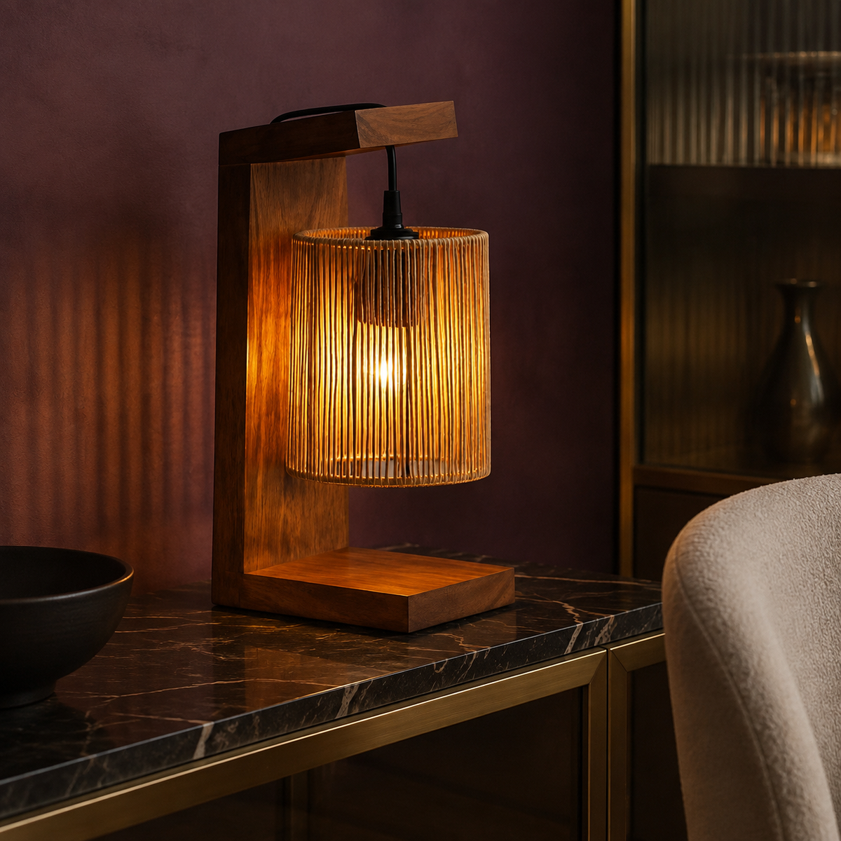 Woven raffia lamp on marble surface with plum wall background