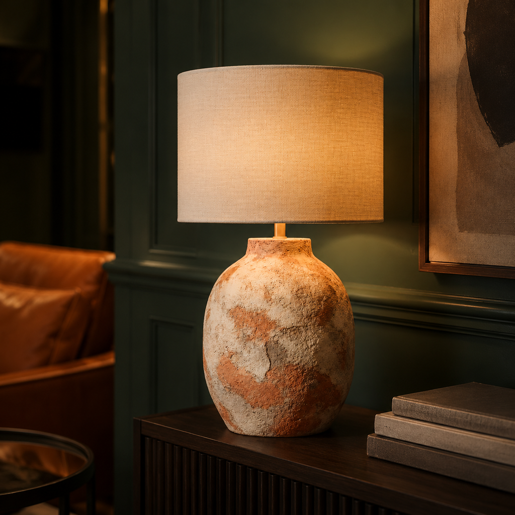 Warm rustic lamp on dark sideboard in green reading room