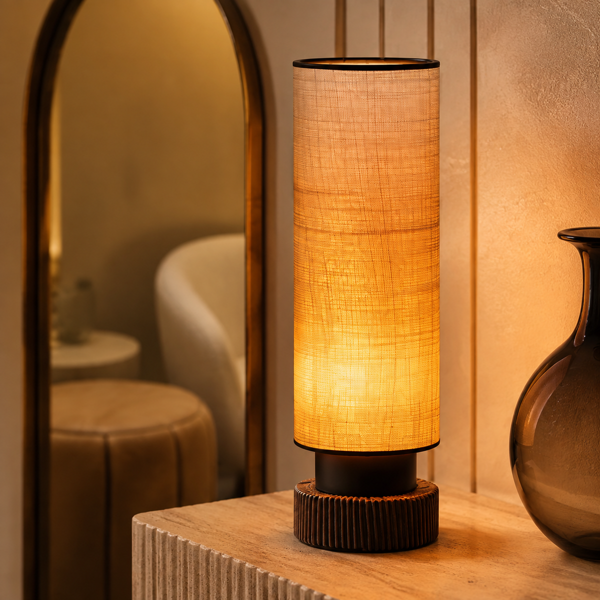 Tall amber woven lamp on limestone console beside arched mirror